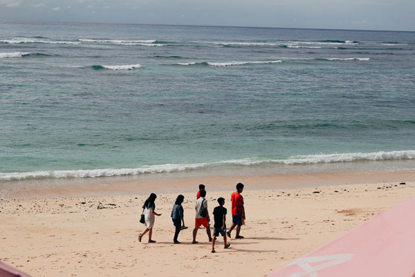 Local teenagers walking in Kuta Beach