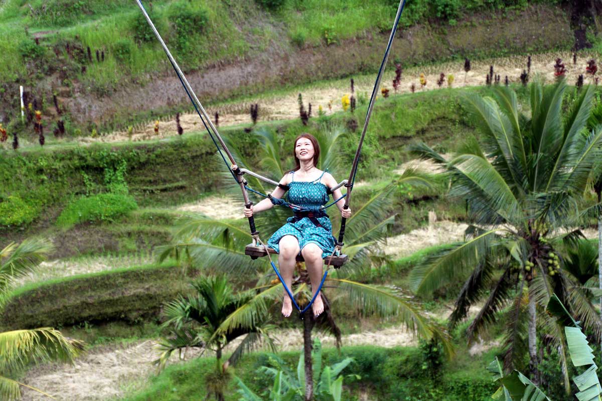 A tourist enjoying a swing in Ubud