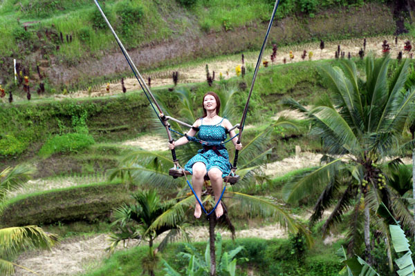 A tourist enjoying a swing in Ubud