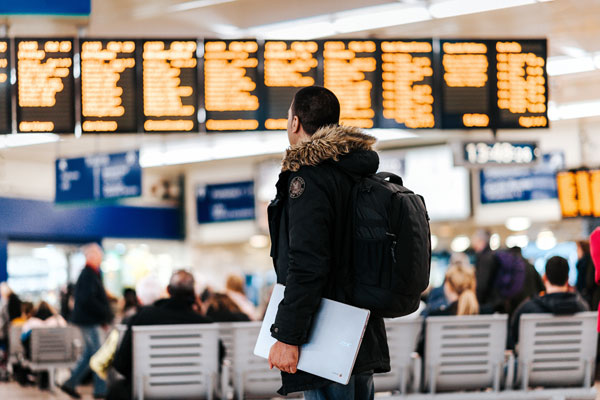 A tourist looking at the flight schedule at the airport